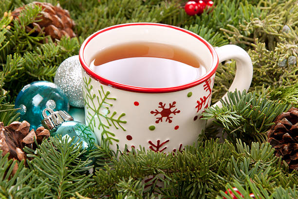 Christmas Mug with drink Christmas mug with tea decorated with red and green snowflakes pine and fir cone ornament in the morning pine needle tea stock pictures, royalty-free photos & images