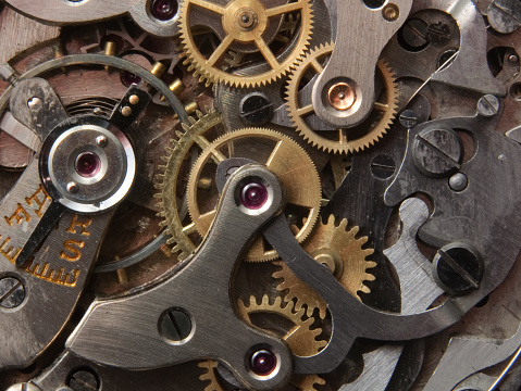 Close-up of the internal mechanism of an uncared-for antique clockwork, wind-up wristwatch.