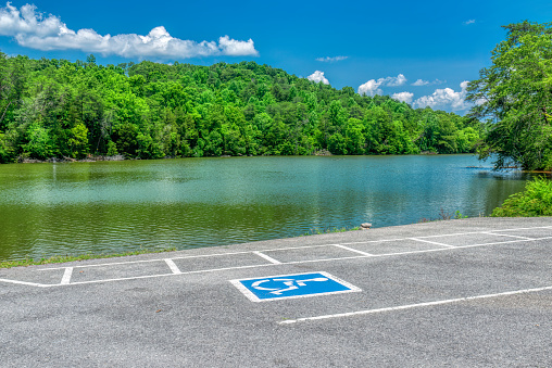 Horizontal shot of a handicap parking space next to the Tennessee River in summertime.