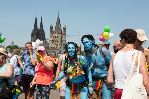 Cologne, Germany - July 9,2023: The christopher street day parade in Cologne has just started on the Deutzer Brückeat a very hot summer day, Participants oft he parade wearing fanciful costumes in vibrant colors, Cologne cathedral can be seen in the background