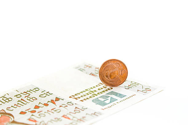 Old Irish Penny and Pound on White Background Old Irish penny and pount (punt) on white background. irish punt note stock pictures, royalty-free photos & images