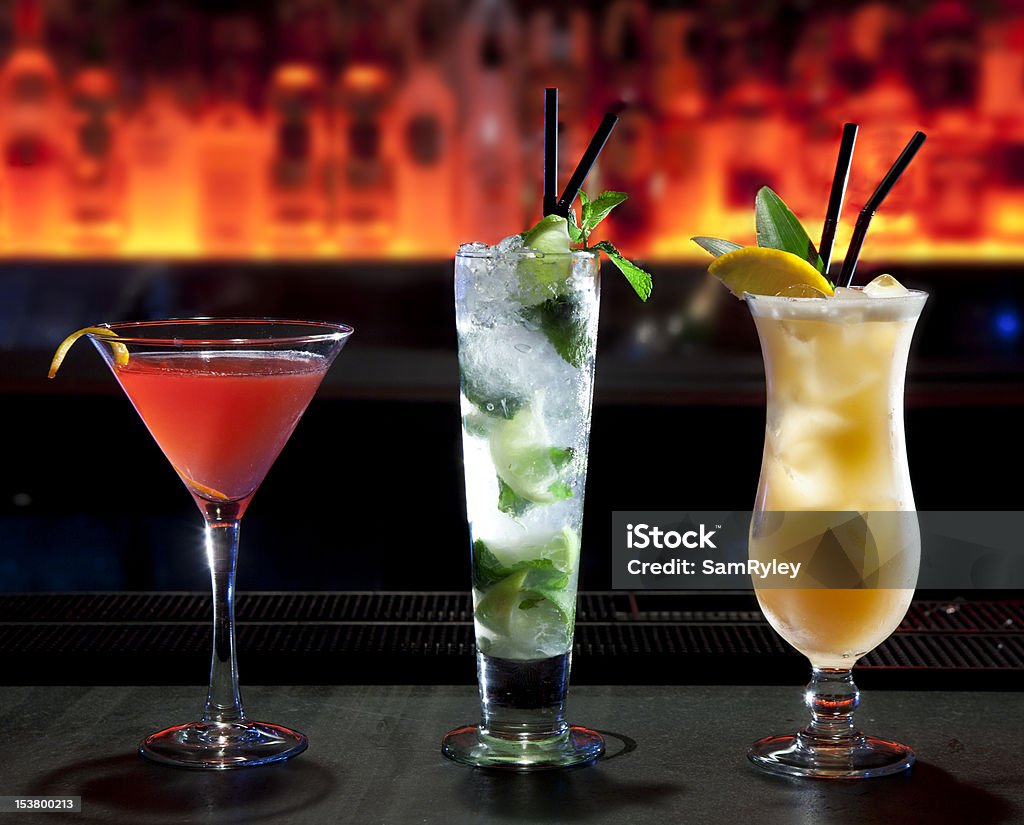 Three cocktails on the bar Three different alcoholic cocktails standing on a bar counter Cocktail Stock Photo
