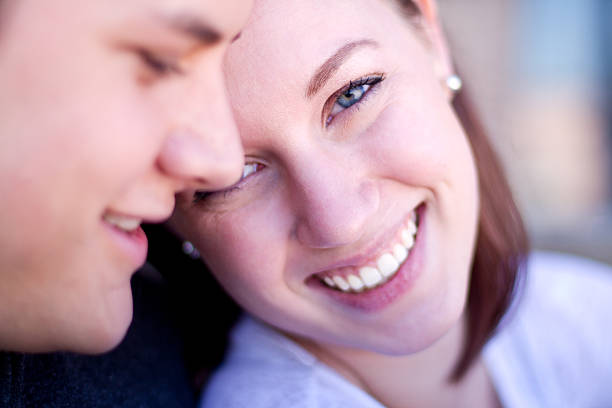Portrait of a young couple. Shot in studio on black background with Canon 5D MkII and EF 85mm f/1,2L. Developed in Lightroom and Photoshop.