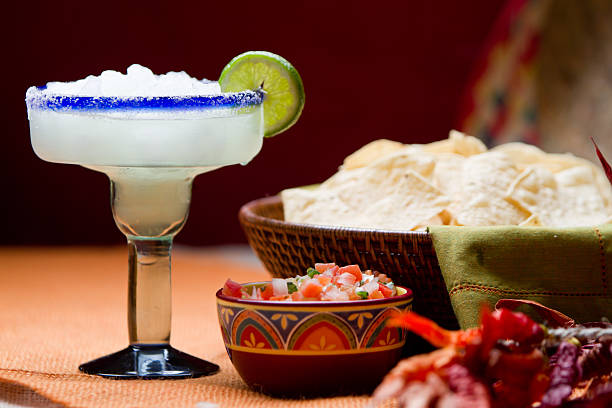 Chips, Salsa and Margarita Mexican Food and Drink Traditional Mexican Chips, Salsa and Frozen Margarita with salt and lime on the rim of the glass on a table with Mexican decor. margarita stock pictures, royalty-free photos & images