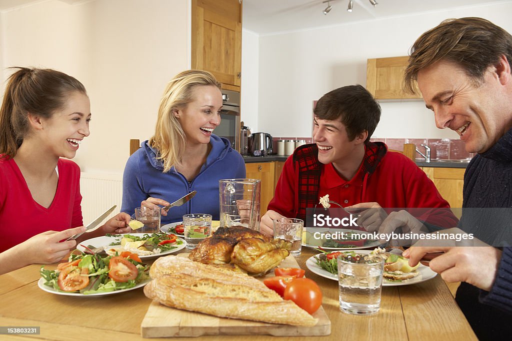 Teenage familia comiendo juntos en la cocina almuerzo - Foto de stock de Familia libre de derechos