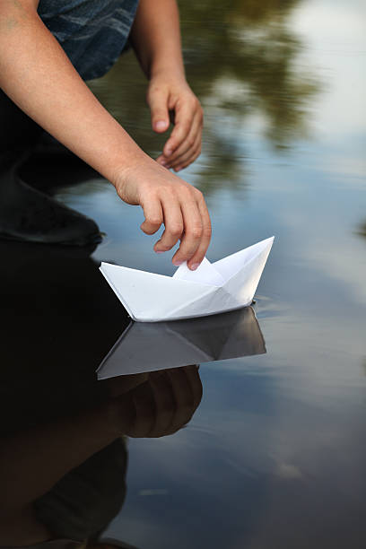 istock paper ship in children hand 153807645