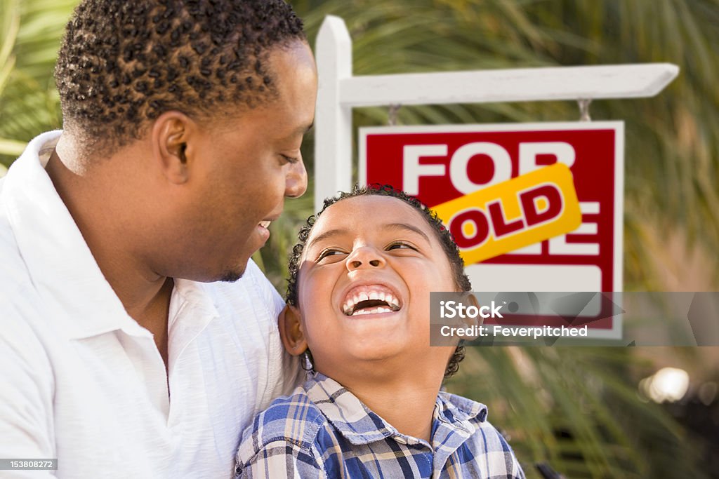 Pai e filho na frente do sinal vendido imóveis - Foto de stock de Bens imóveis royalty-free