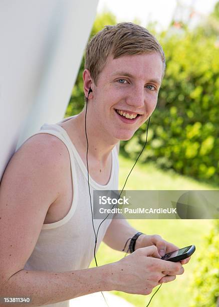 Szczęśliwy Młody Człowiek Słuchając Odtwarzacza Mp3 Telefon Komórkowy - zdjęcia stockowe i więcej obrazów 16-17 lat