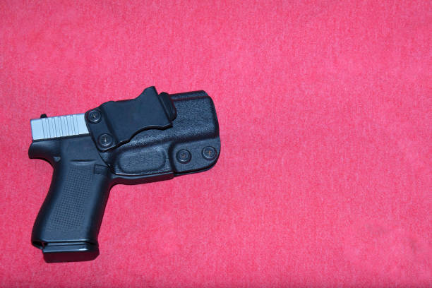 istock Hand gun in holster on red background, 1538138813
