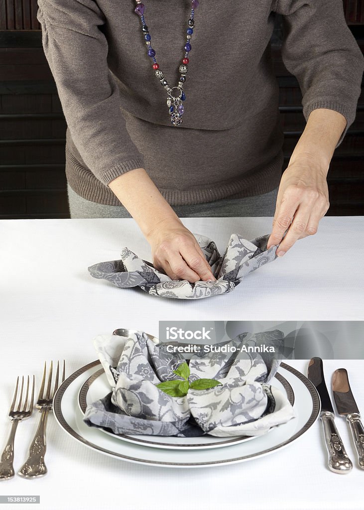 Napkin folding Hands of a woman folding napkins for a fancy dinner table Adult Stock Photo