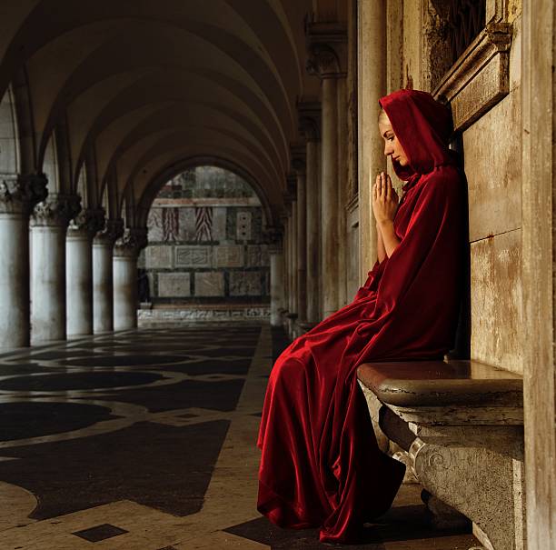 istock Woman in red cloak praying alone 153814806
