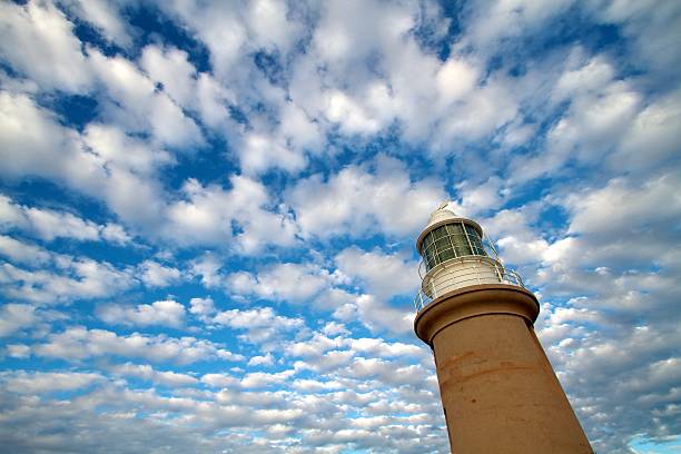 Lighthouse with blue sky and white cloud background stock photo