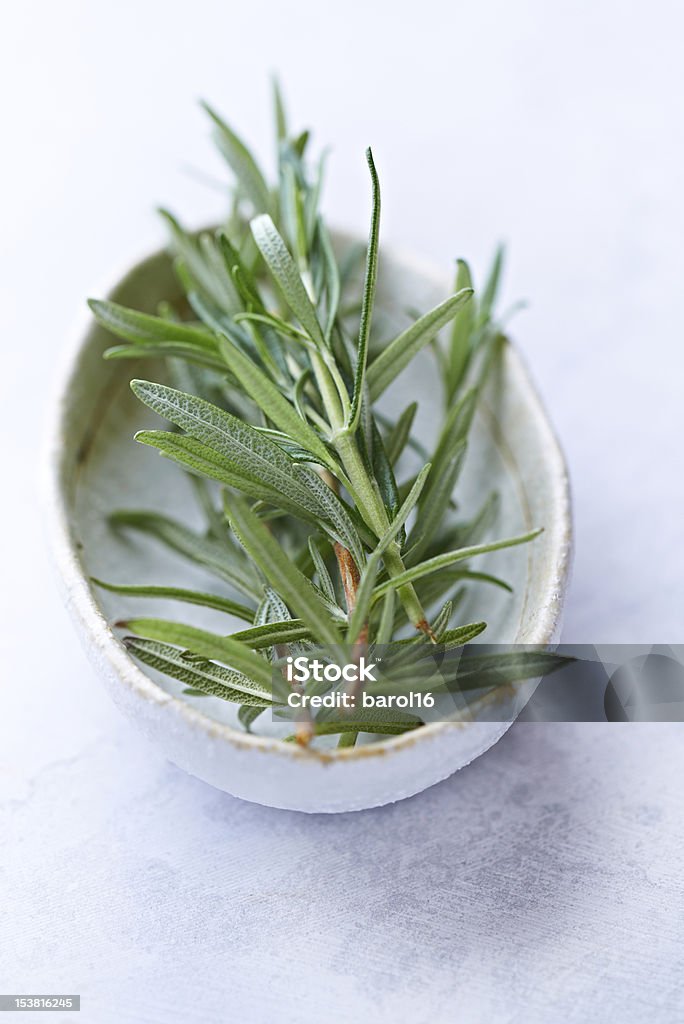 Fresh rosemary sprigs in a ceramic bowl close up of fresh rosemary sprigs in a white ceramic bowl Bowl Stock Photo