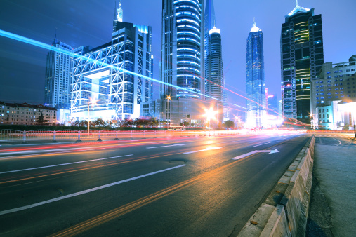 Modern office building background of car night with light trails in Shanghai