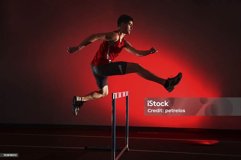 Atleta correndo obstáculos isolado no fundo vermelho - Foto de stock de Obstáculo de Corrida royalty-free