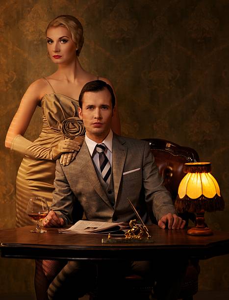Retro couple sitting behind table.