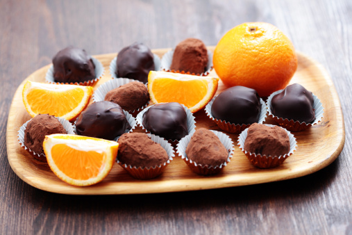 orange and chocolate pralines on brown - sweet food