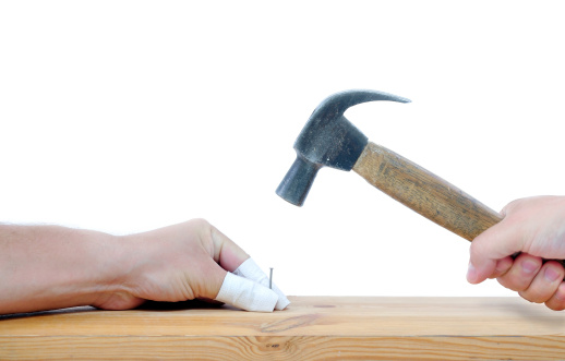 carpenter with hammer and nail trying to avoid another injuries