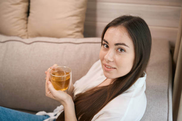 istock Smiling pretty young lady sitting on couch 1538252984