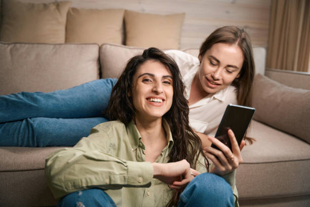 istock Two smiling females having fun using phone 1538253529