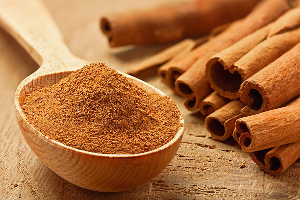 Cinnamon sticks and powder Cinnamon sticks and powder, studio shot, wood surface, stick plant part photos stock pictures, royalty-free photos & images