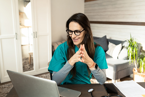 Female doctor talking with colleagues through a video call