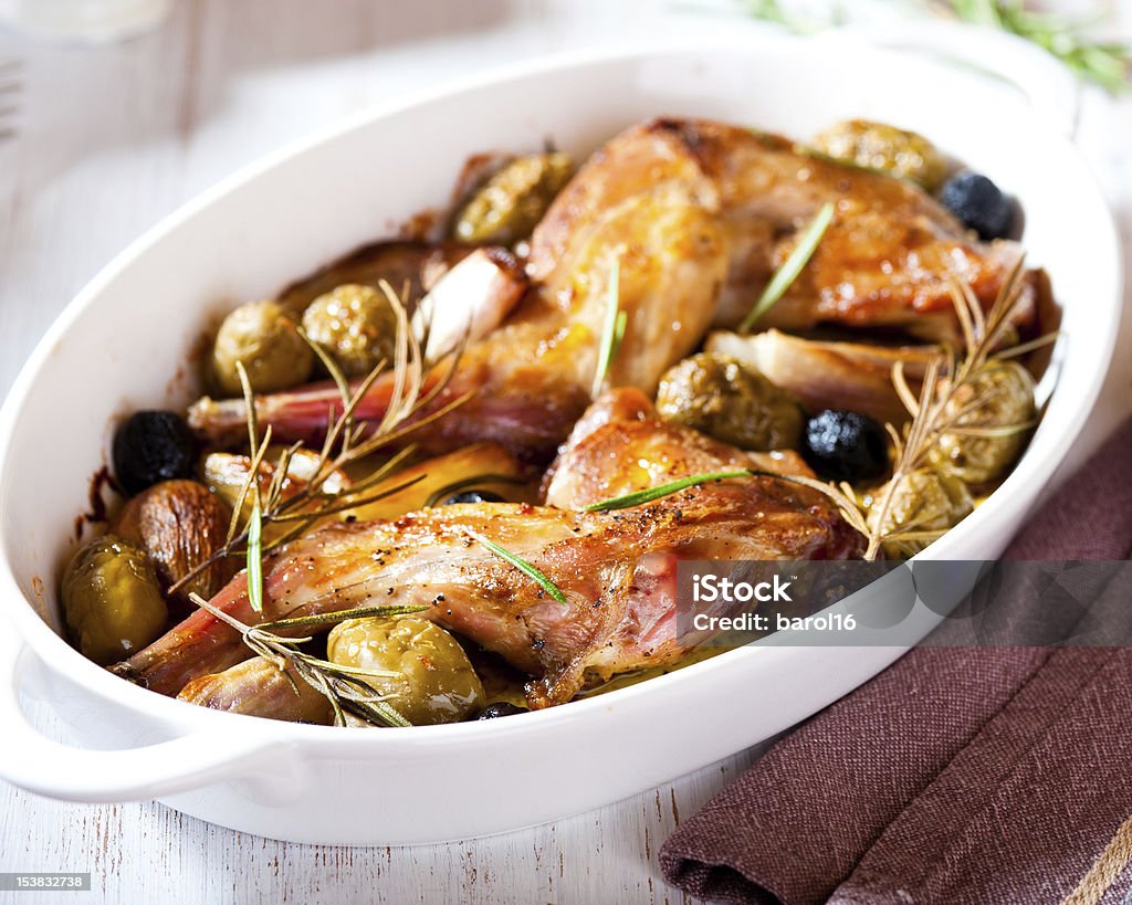 Oven baked rabbit legs with olives and rosemary Oven baked rabbit legs with olives and rosemary  Baked Stock Photo