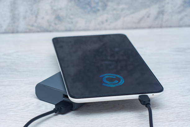 istock The Tablet is being charged using a portable charger on a wooden table. 1538340859