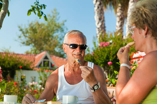 istock Old couple eating cake int he garden 153835680