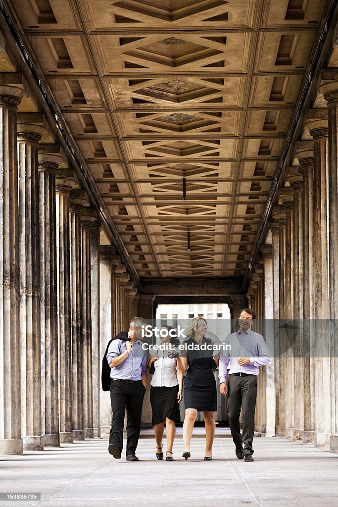 Cuatro elegantes personas caminando en columnas paso - Foto de stock de 30-39 años libre de derechos