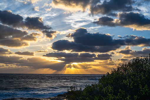 The sun is setting in the clouds over the sea in distance, Eleuthera