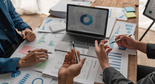 istock Businessman team analyzing financial statement finance task with calculator and laptop. Wealth management concept 1538621375