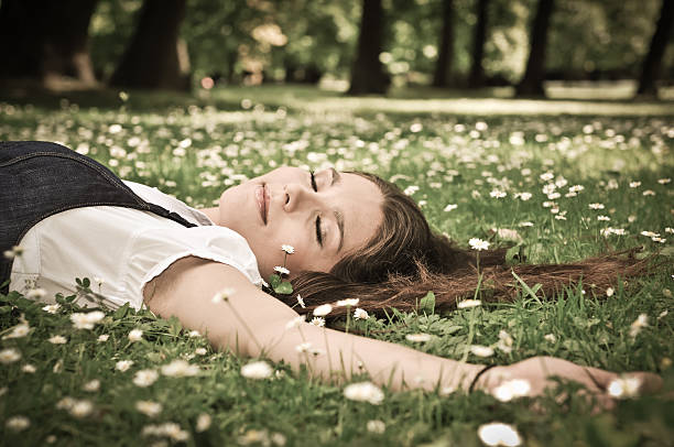 istock Young woman lying in grass with flowers 153866939