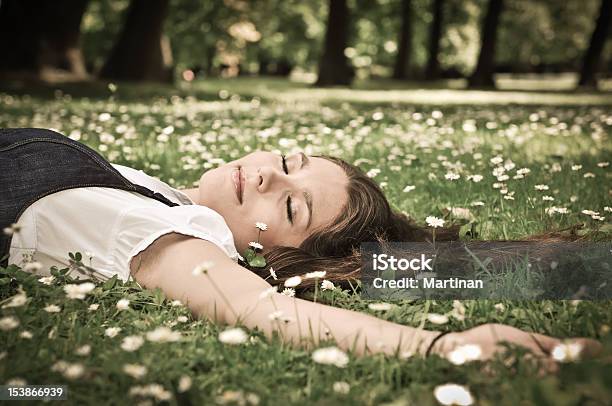 Foto de Jovem Mulher Deitada Na Grama Com Flores e mais fotos de stock de Adolescente - Adolescente, Adulto, Alegria