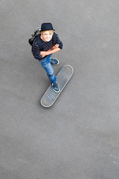 istock teen skateboarder standing on skateboard 153870358