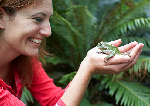 Woman holding  frog, smiling