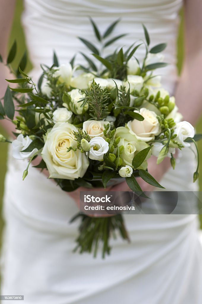Panna młoda trzyma bukiet kwiatów - Zbiór zdjęć royalty-free (Biały)