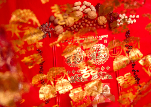 Nuts and red envelopes on a red tabletop, bokeh foreground, festive pictures of oriental countries, pictures of weddings and happy events(Translation: \