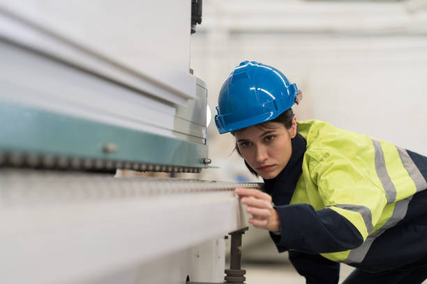 trabalhadora engenheira verificando máquina de correia transportadora na fábrica da indústria. técnica feminina usa uniforme de segurança trabalhando com manutenção da máquina na fábrica - cnc vehicle part quality control industry - fotografias e filmes do acervo