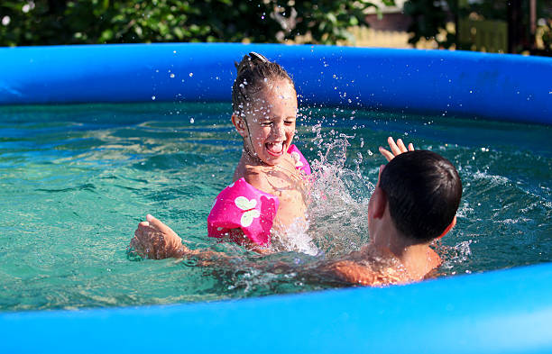 Kids having fun in the swimming pool stock photo