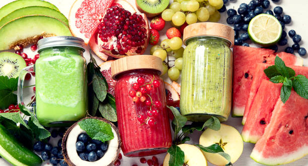 istock Fresh fruit and vegetable smoothies or juice  with various ingredients on light background. 1538832022