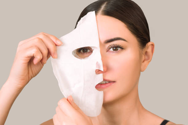 istock woman removing a moisturizing fabric mask from her face with her hand after using it 1538835178