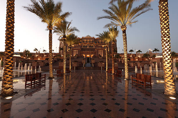 Emirates Palace Mandarin Oriental in Abu Dhabi, UAE. The majestic hotel features intricate architectural details surrounded by palm trees, side view, April, 2023