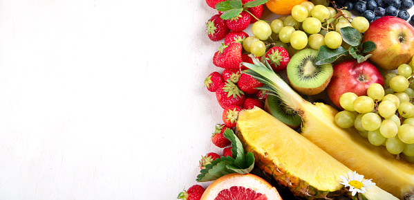 Fresh fruits, assorted fruits on a white background. Vitamins natural nutrition concept. Panorama with copy space.
