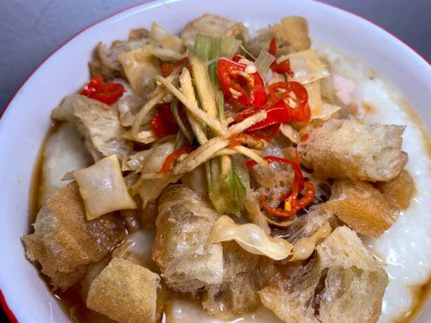 istock Shredded chicken boiled rice with ginger, peanuts, cakwe and sliced chilies. Top view. Close up. Porridge chicken. 1538840346