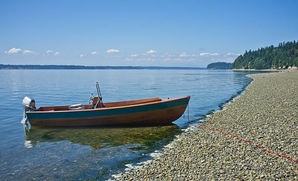 Wooden boat on rocky shore, Puget Sound, Washington stock photo