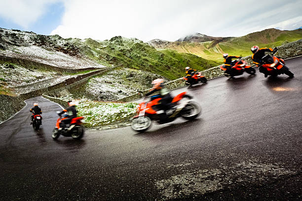 a team of motorcyclists traversing a mountainous road
