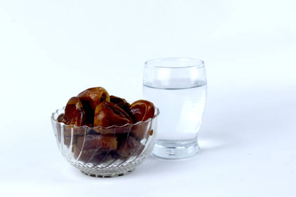 istock Dates and a glass of water isolated on a white background 1538876527