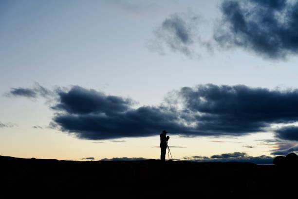 istock Photographer silhouette at sunset under cloudy sky 1538876562