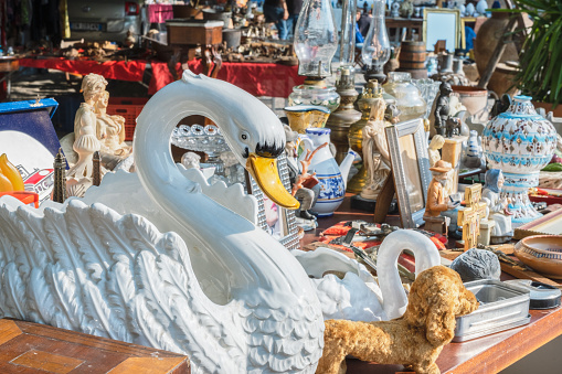 The weekend flea market on the city square in Cannes, France.  Vendors bring their merchandise of all types for sale at the weekend market.   The market is popular with tourist and residents alike.